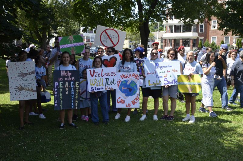 Group of people with signs standing in the park.